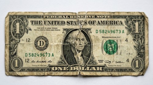 Un primer plano detallado de un billete de dólar estadounidense muy deteriorado y roto aceptado para cambio por Eurochange